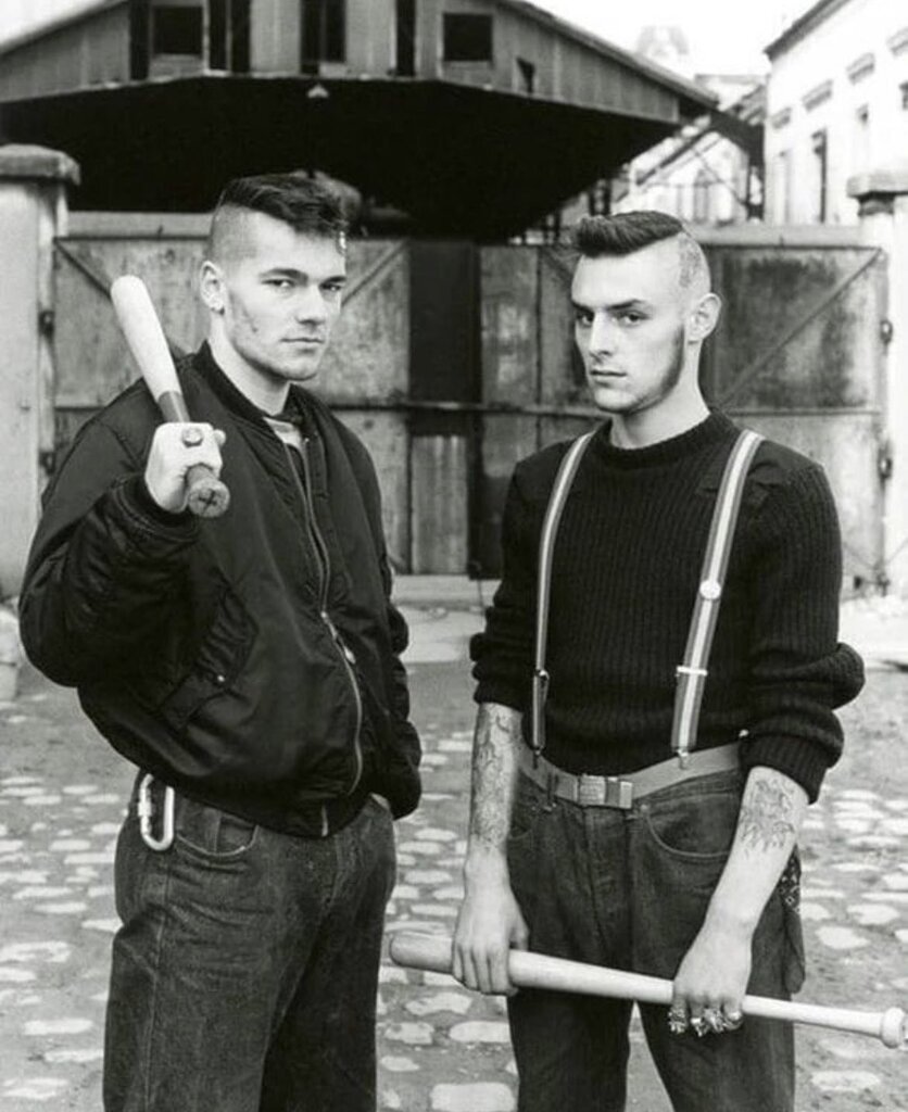 AI caption: two men standing next to each other holding baseball bats, black and white