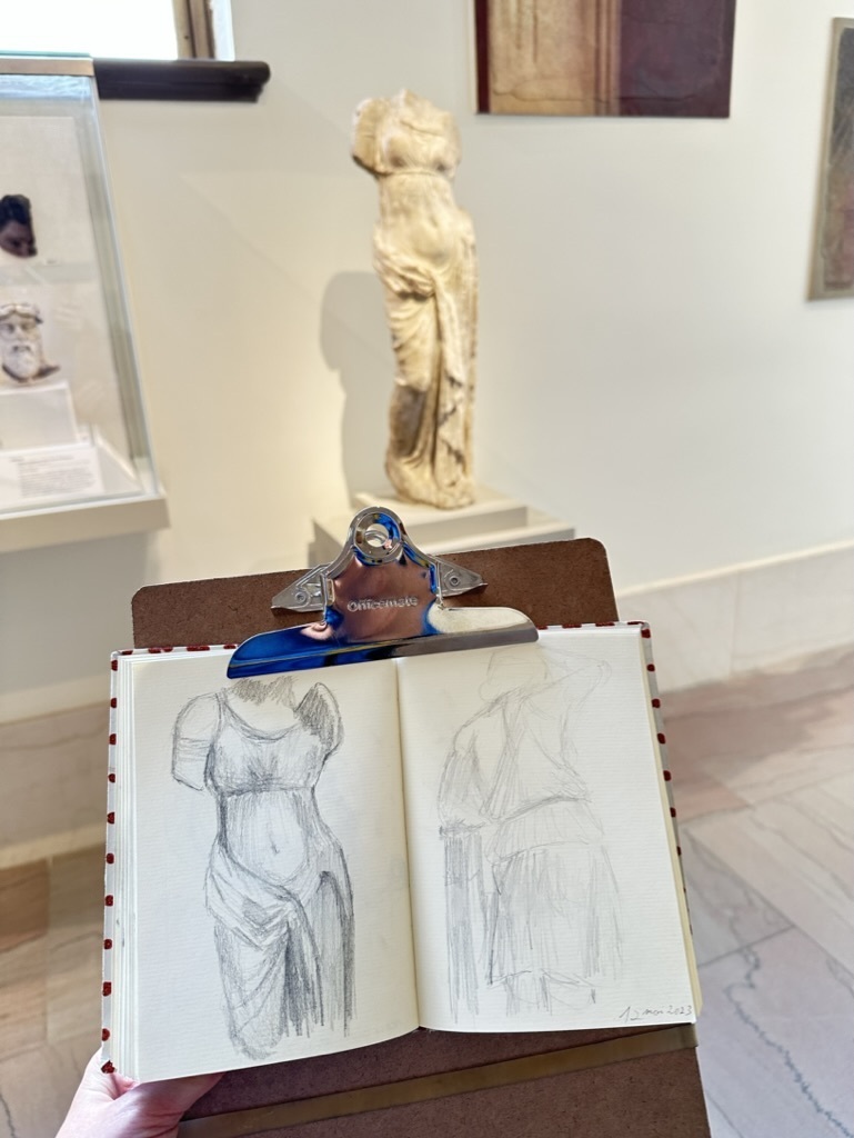 AI caption: a person is drawing a statue in front of a drawing board, sketching