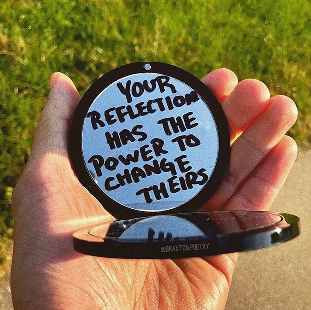 AI caption: a person holding a mirror with the words'your reflection has the power to change this', handwritten