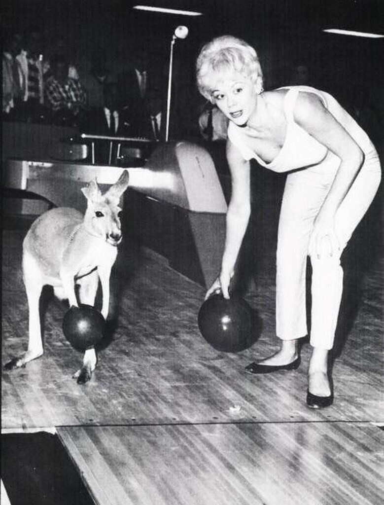 AI caption: a woman bowling with a kangaroo, black and white