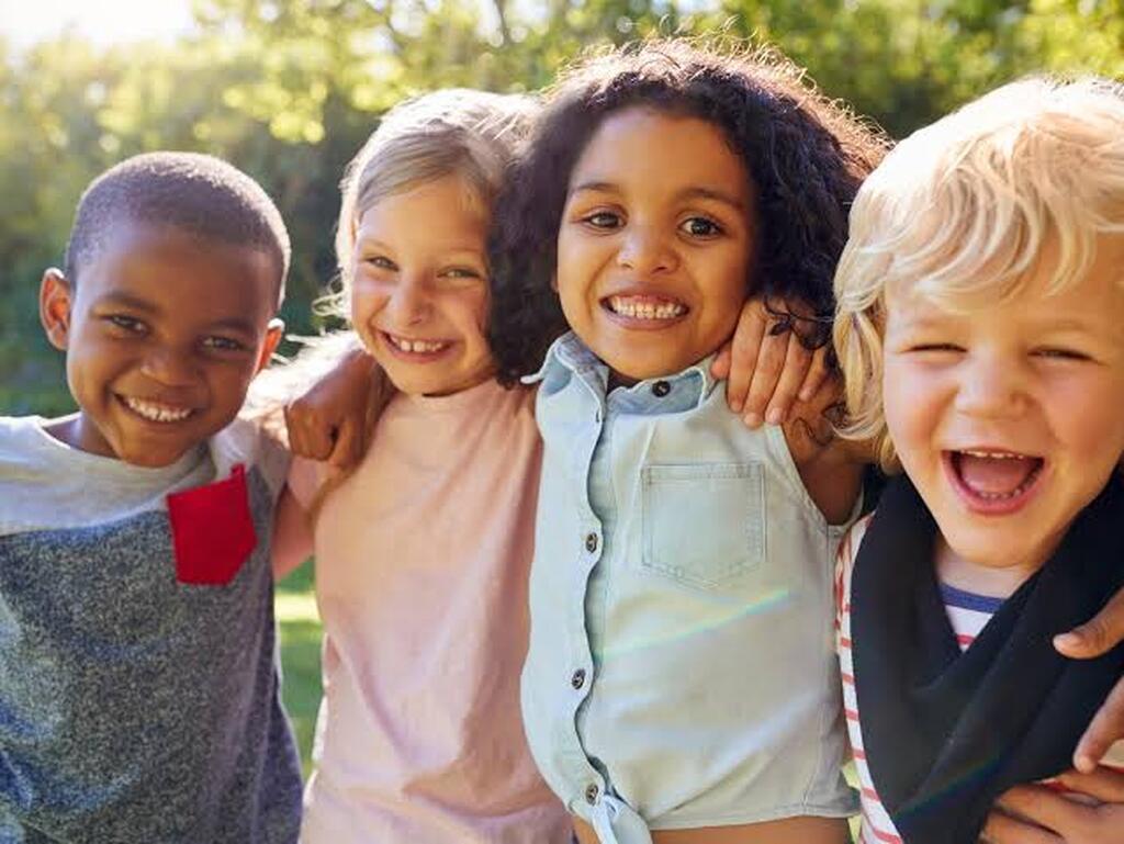 AI caption: a group of kids are smiling together in the park, portrait