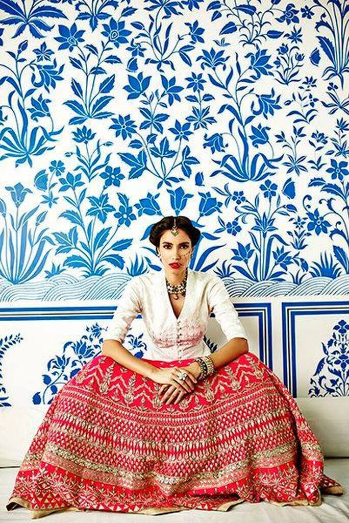 AI caption: a woman in a blue and white dress sitting on a bed, indian style