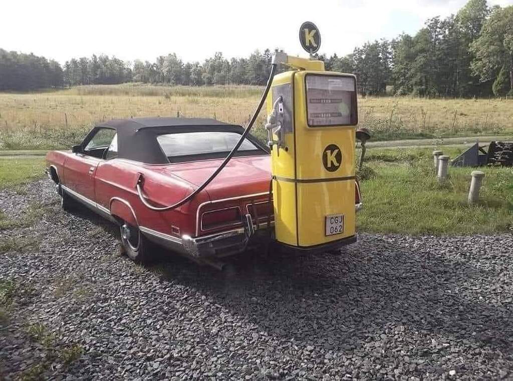 AI caption: a red and yellow car with a gas pump, vintage