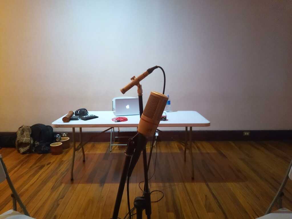 AI caption: the building where the hotel is located, architectural a room with a table and chairs, , a room with a table and chairs a microphone is set up in a room with chairs, the microphone is in the middle of the room