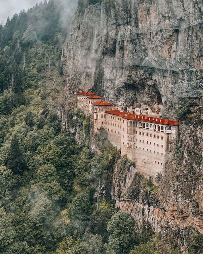 AI caption: a monastery is sitting on top of a cliff, adobe