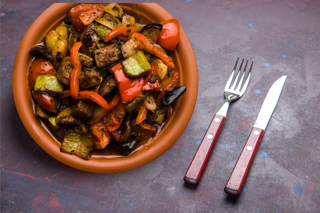 AI caption: a plate of vegetables and meat with a fork and knife, flat lay