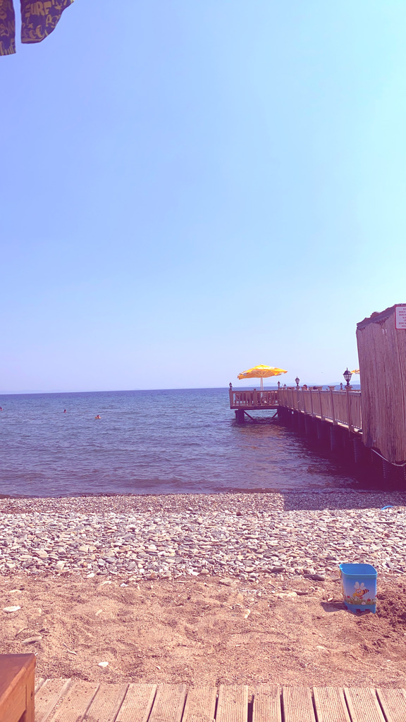 AI caption: a beach with a pier and chairs, a beach scene