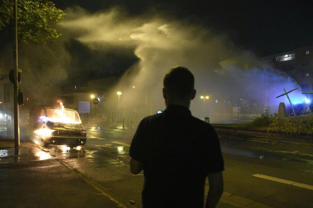 AI caption: a man stands in front of a fire hose in a city, black and white