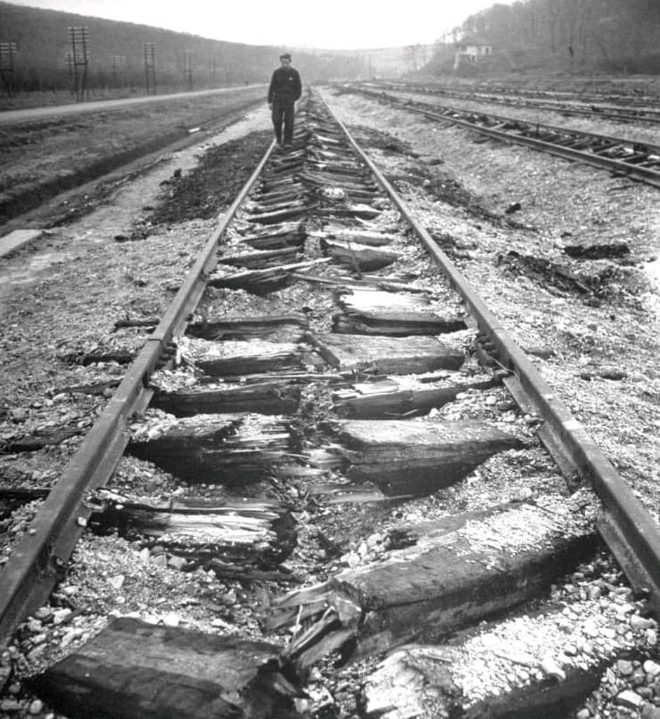 AI caption: a man walking along the railroad tracks, black and white