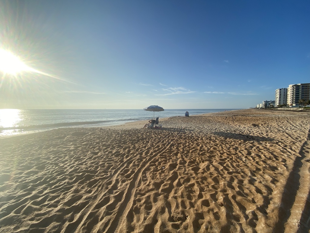 AI caption: a beach with a sun shining on it, panoramic